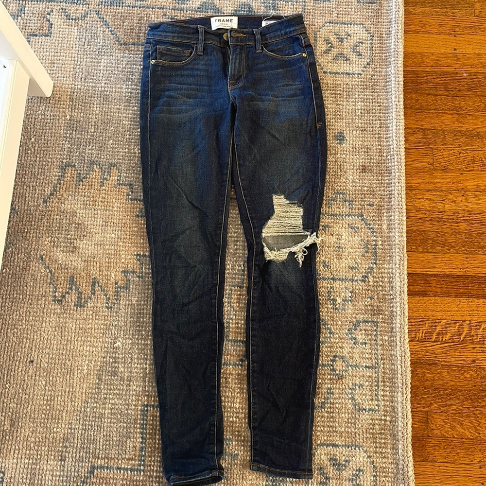 Frame Le skinny de Jeanne with rip on left knee.